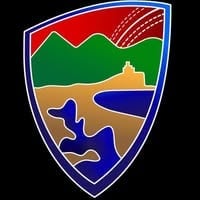 Shield emblem with green mountains, wheat field, blue water, and yellow sun representing nature and agricultural landscape